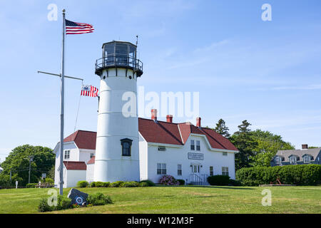 Chatham, MA - Giugno 15, 2019: U.S. Stazione della Guardia Costiera e del faro con Stati Uniti e Guardia Costiera bandiere nel vento. Foto Stock