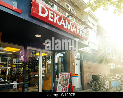 Haarlem, Paesi Bassi - 20 AGO 2018: lusso DekaMarkt supermercato ingresso con luce solare e flare belle biciclette Foto Stock