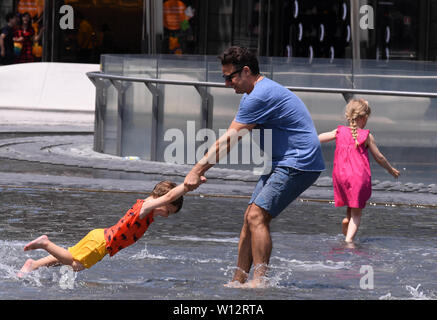 Milano, Italia. Il 29 giugno, 2019. Le persone giocano in una fontana di Milano, Italia, il 29 giugno 2019. Sedici città italiane sono in allerme dopo due uomini anziani morti da colpo di calore in ciò che è pubblicizzato come una delle più intense ondate di caldo per colpire l'Italia negli ultimi anni. Credito: Alberto Lingria/Xinhua/Alamy Live News Foto Stock