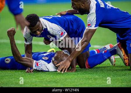 Houston, TX, Stati Uniti d'America. Il 29 giugno, 2019. Membri del team di Haiti pila sulla sommità del centrocampista Wilde-Donald Guerrier (10) dopo aver segnato il gol vincente durante la seconda metà di un CONCACAF Gold Cup quarti di finale partita di calcio tra Haiti e in Canada presso NRG Stadium di Houston, TX. Haiti ha vinto 3 a 2.Trask Smith/CSM/Alamy Live News Foto Stock