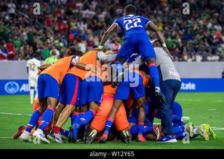 Houston, TX, Stati Uniti d'America. Il 29 giugno, 2019. Membri del team di Haiti pila sulla sommità del centrocampista Wilde-Donald Guerrier (10) dopo aver segnato il gol vincente durante la seconda metà di un CONCACAF Gold Cup quarti di finale partita di calcio tra Haiti e in Canada presso NRG Stadium di Houston, TX. Haiti ha vinto 3 a 2.Trask Smith/CSM/Alamy Live News Foto Stock