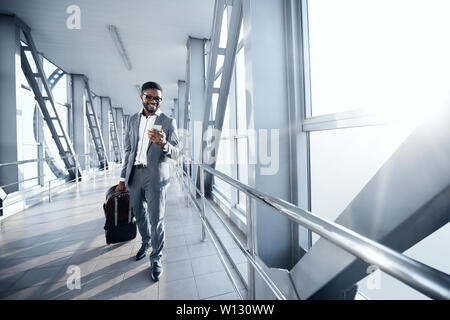 Imprenditore Afro all aeroporto di passare a gate terminale Foto Stock