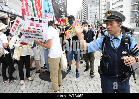 Osaka, Giappone. Il 29 giugno, 2019. Un funzionario di polizia dirige il traffico di una protesta di Osaka in Giappone. Osaka è stato ospite del vertice del G20 che si è svolta Venerdì, Giugno 28 e 29. Foto scattata su Sabato, 29 giugno 2019. Foto di: Ramiro AgustÃ n-Vargas Tabares Credito: Ramiro Agustin Vargas Tabares/ZUMA filo/Alamy Live News Foto Stock