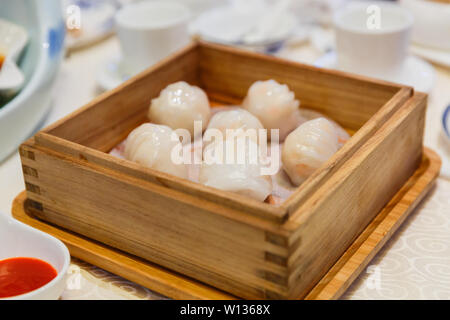 Una scatola di gnocchi di cristallo in un sistema per la cottura a vapore in legno sulla tavola di hotel. Foto Stock