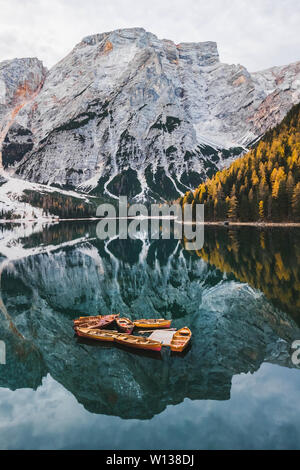 Paesaggio autunnale del lago di Lago di Braies nelle Dolomiti italiane montagne del nord Italia. Drone foto aerea con le barche in legno e splendidi reflectio Foto Stock