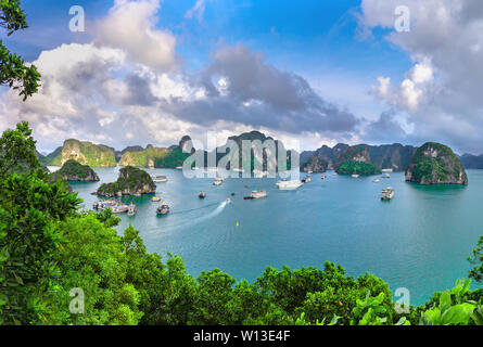 La baia di Ha Long vista panorama. Isola e rocce in mare con navi crociera intorno con tourist. Foto Stock