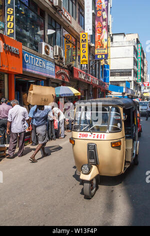 Colombo. Sri Lanka - 21 dicembre 2016: un tuk tuk si fa strada giù per una strada nel quartiere di Pettah. Questa è la zona commerciale principale. Foto Stock