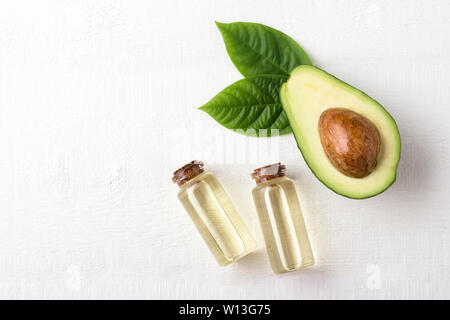 Olio di avocado su bianco sullo sfondo di legno Foto Stock