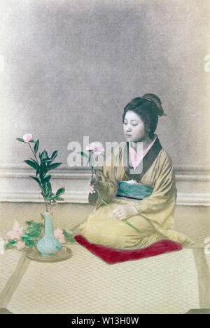 [ 1890 Giappone - dimostrazione di Ikebana ] - donna in kimono con tradizionale acconciatura facendo "ikebana', in stile Giapponese floreale. Durante la Meiji e Taisho periodi, ikebana e chado (cerimonia del tè) erano un modo popolare di culturalmente illuminare se stessi, soprattutto per le giovani donne sulla soglia del matrimonio. Xix secolo albume vintage fotografia. Foto Stock