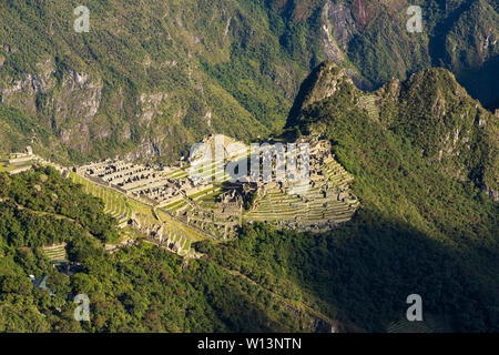 Vista sulla cittadella di Machu Picchu all'alba come il sole sorge a colpire il perso città Inca, Urubamba, regione di Cusco, Perù, Sud America Foto Stock