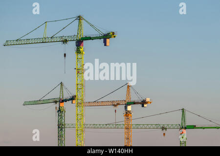 Quattro coloratissimi alta gru a torre nella luce della sera in una serata estiva Foto Stock