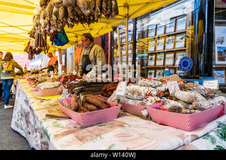 I grappoli di essiccato francese di salsicce, salami, pendente dal mercato francese di stallo con molti più curate e salsiccia secca sul display del contatore di stallo. Foto Stock