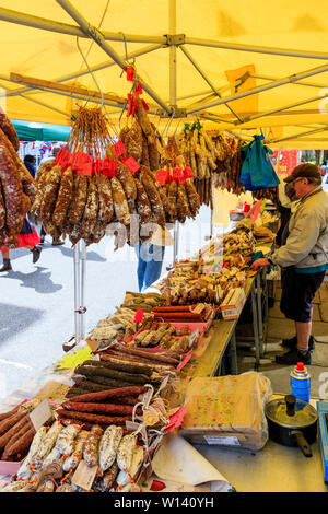 I grappoli di essiccato francese di salsicce, salami, pendente dal mercato francese di stallo con molti più curate e salsiccia secca sul display del contatore di stallo. Foto Stock