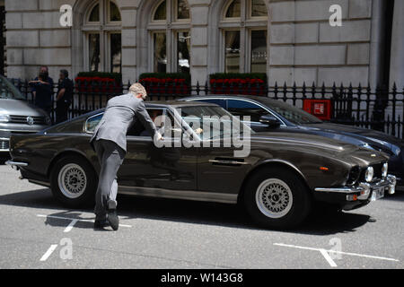 Una controfigura sorge accanto a un Aston Martin come riprese per il prossimo film di James Bond avviene sul Mall a Londra. Il come-ancora-untitled progetto è stata ripresa in Giamaica e in Pinewood Studios ma il funzionario 007 account Twitter ha confermato la spy film è ora riprese nella capitale. Foto Stock