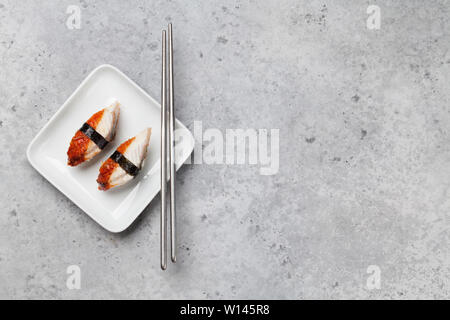 I sushi giapponesi La cucina del set. Unagi. Sashimi, rotoli maki. Sulla piastra su sfondo di pietra con spazio per il testo Foto Stock