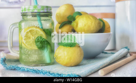 Limonata fatta in casa con la menta, ghiaccio e fettine di limone fresco a mason jar Foto Stock