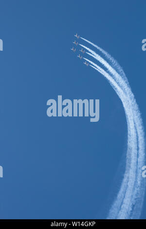 Kunstflugvorführung der "Patrouille de France " mit Alpha-Jets tiefblauen am Himmel, weisse Kondensstreifen in einer weiten Kurve aufwärts Foto Stock