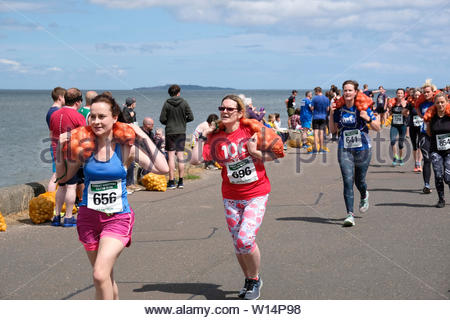 Edimburgo, Scozia, Regno Unito. Il 30 giugno 2019. Il grande scozzese Tattie correre a Silverknowes Promenade, organizzata da grandi eventi scozzese, un evento di beneficenza organizzatore Gruppo. La gara è per un miglio con un sacco di patate 20 chilo per uomini,10 chilo per le donne. Tutti i partecipanti ricevono per mantenere la loro borsa di tatties. Credit:Craig Brown Foto Stock