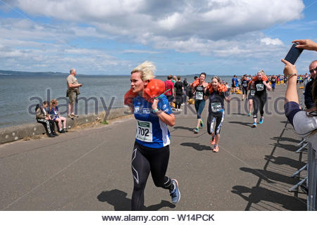 Edimburgo, Scozia, Regno Unito. Il 30 giugno 2019. Il grande scozzese Tattie correre a Silverknowes Promenade, organizzata da grandi eventi scozzese, un evento di beneficenza organizzatore Gruppo. La gara è per un miglio con un sacco di patate 20 chilo per uomini,10 chilo per le donne. Tutti i partecipanti ricevono per mantenere la loro borsa di tatties. Credit:Craig Brown Foto Stock