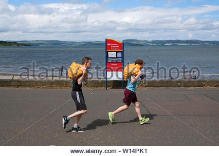 Edimburgo, Scozia, Regno Unito. Il 30 giugno 2019. Il grande scozzese Tattie correre a Silverknowes Promenade, organizzata da grandi eventi scozzese, un evento di beneficenza organizzatore Gruppo. La gara è per un miglio con un sacco di patate 20 chilo per uomini,10 chilo per le donne. Tutti i partecipanti ricevono per mantenere la loro borsa di tatties. Credit:Craig Brown Foto Stock