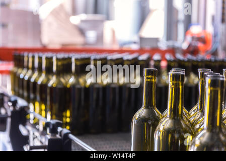 Le bottiglie di vino sfondo, processo di vinificazione per la preparazione di vini per imbottigliamento in una cantina Foto Stock