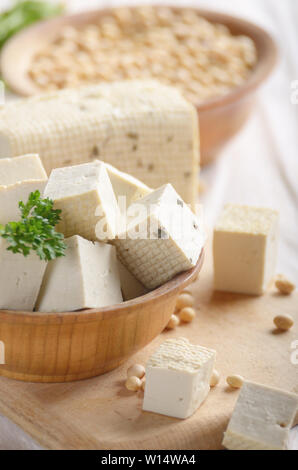 Fagiolo di Soia Curd tofu in ciotola di legno su legno bianco tavolo da cucina. Non a base di latte sostituto alternativo per il formaggio. Posto per il testo Foto Stock