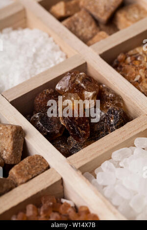 I vari tipi di zucchero in una scatola di legno. Raffinato bianco, marrone zucchero di canna raccolta Foto Stock