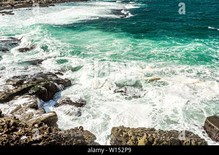 Le onde che si infrangono sulle rocce calcaree a spiaggia Bothar nA hAillite, geoparks geosites, Wild Atlantic modo, splendida giornata di primavera nella contea di Clare in Irlanda Foto Stock