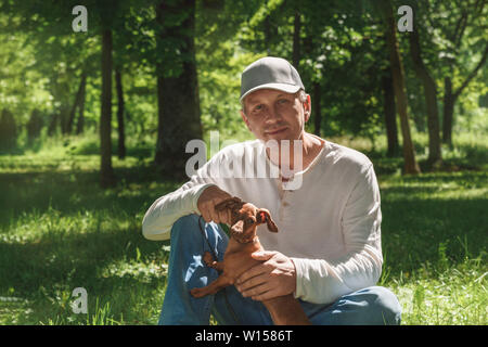 Giovane ragazzo con retriever sulla passeggiata nel parco di estate Foto Stock