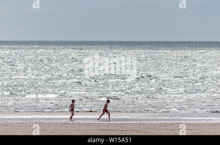 Troon, Scotland, Regno Unito. Il 30 giugno, 2019. Regno Unito Meteo. Passeggiate sulla spiaggia di South Beach su un luminoso pomeriggio. Credito: Berretto Alamy/Live News Foto Stock