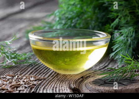Una ciotola di aneto semi di olio con Anethum graveolens semi e foglie Foto Stock