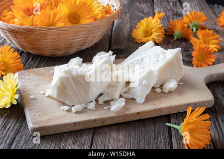 Ingredienti per parepare a casa la Pomata alla Calendula per digestione - grezzo grezzo di burro di karité e freschi fiori di tagete Foto Stock
