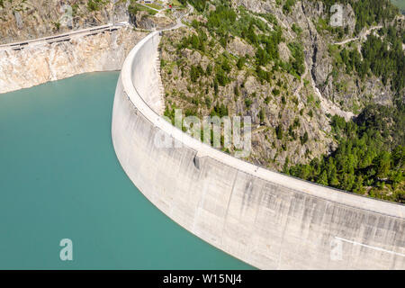 Serbatoio acqua Lac de Emosson, antenna fuco shot della diga muro, persone che camminano nella diga, Lac d'Emosson, canton Vailais, Vallese, Svizzera. Foto Stock