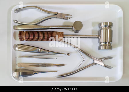 Gli strumenti chirurgici impostato o apparecchiature mediche sul vassoio bianco su bianco piano di lavoro di laboratorio Foto Stock