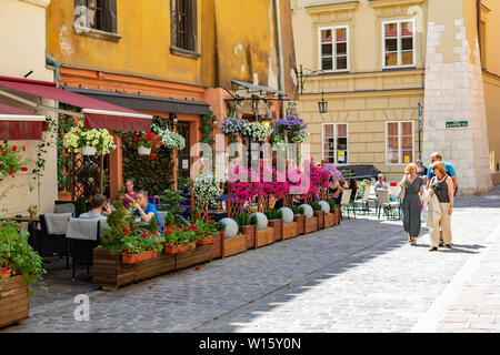 La Polonia, Cracovia, 10 maggio 2019 - piccolo cafè locale nel centro di Cracovia, fiori decorare, strade acciottolate piena di gente, Cracovia in Polonia Foto Stock