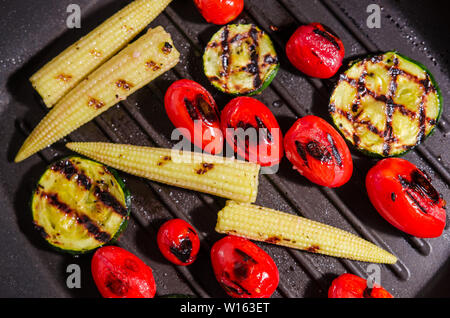 Grigliata di verdure - zucchine, baby mais, pomodoro ciliegino Foto Stock