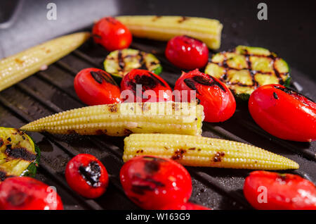 Grigliata di verdure - zucchine, baby mais, pomodoro ciliegino Foto Stock