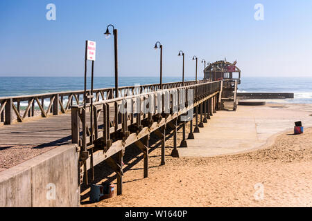 Pontile in legno raggiungendo il oceano Atlantico, Langstrand, Namibia Foto Stock