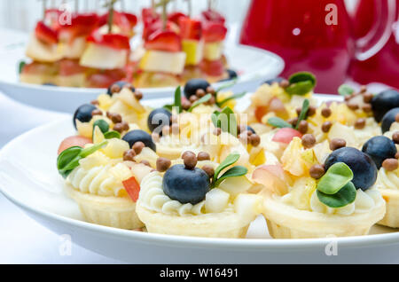 Set di deliziosi pasticcini con crema, frutta e mirtilli Foto Stock