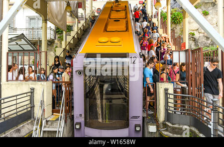 COMO, Italia - Giugno 2019: persone salire e scendere un treno sulla ferrovia funicolare di Como. La stazione ferroviaria porta i visitatori fino alla montagna Foto Stock