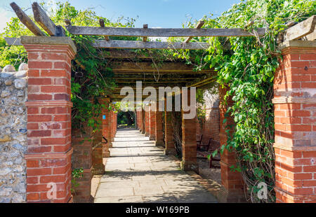 In mattoni rossi costruito pergola tradizionale in Connaught giardini, Sidmouth, un piacevole popolare south coast città balneare nel Devon, sud-ovest Inghilterra Foto Stock