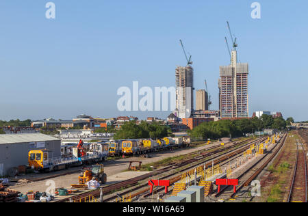La modifica skyine di Woking, Surrey: tracce ferroviarie il piombo in gru a torre e il nuovo aumento elevato uso misto sviluppi nel centro della città Foto Stock