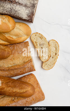 Cereali integrali, pane bianco e bruno con le fette su sfondo bianco, Verticale in alto vista, lo spazio libero per il testo Foto Stock