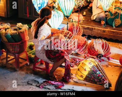 Donna vietnamita rendendo i tradizionali colorati Hoi An lanterne Foto Stock