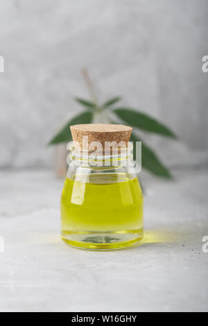 Olio di Cannabis estratti in un vasetto di vetro su uno sfondo grigio Foto Stock