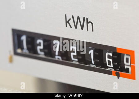 Chiusura del contatore elettrico che mostra il lettore utilizzato kWh in privato casa residenziale con il fuoco selettivo Foto Stock