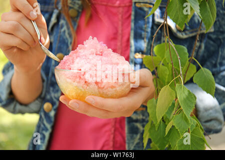 Donna di mangiare saporito rasato ghiaccio all'aperto, primo piano Foto Stock