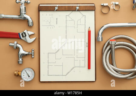 Set di articoli idraulici con piano casa sul colore di sfondo Foto Stock