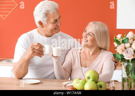Ritratto di felice coppia matura bere il tè a casa Foto Stock