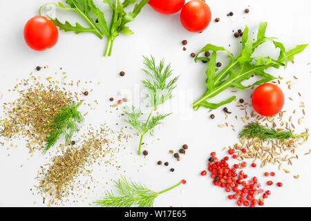 Le erbe fresche con spezie e i pomodori su sfondo chiaro Foto Stock